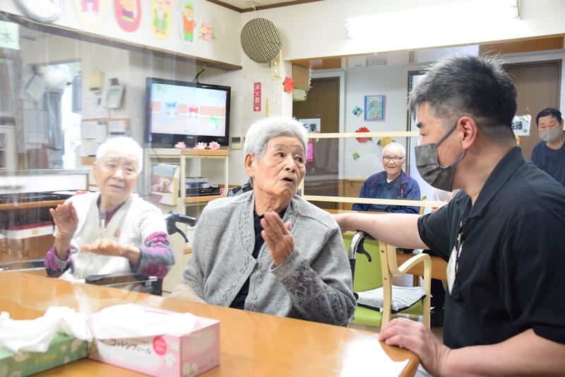 「おおこし」が運営する高齢者施設では、パーティションを置き、職員(右端)がマスクを着用するなど、従来からの感染対策を継続している=7日、千葉市若葉区