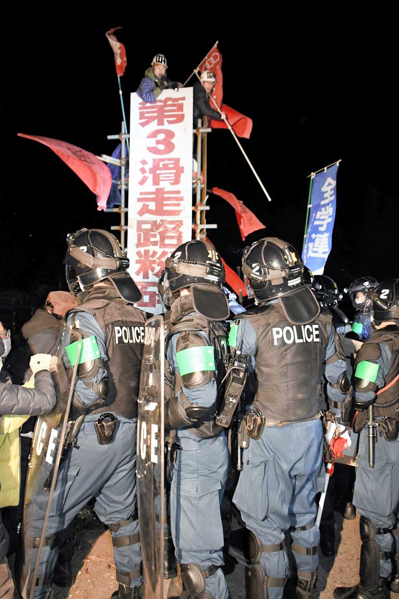 強制執行に向けて空港反対派を取り囲む県警機動隊員=15日午後8時10分ごろ、成田市天神峰